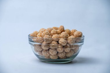 Keciput 'a yakın, geleneksel bir Endonezya susamlı atıştırmalığı, çıtır çıtır dokuları ve otantik sokak yemekleriyle kızartılmış altın yüzeyi gösteriyor..