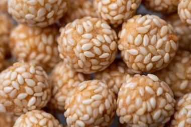 Keciput 'a yakın, geleneksel bir Endonezya susamlı atıştırmalığı, çıtır çıtır dokuları ve otantik sokak yemekleriyle kızartılmış altın yüzeyi gösteriyor..