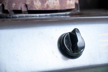 Gri metalik sobanın tepesindeki siyah bir aletin makro görüntüsü günlük mutfak ekipmanları ve ev aletlerini gösteriyor..