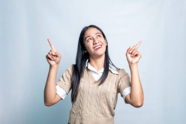 Neşeli, genç Asyalı bir kadın fotokopi odasına bakıyor ve temiz bir arka planda şık kıyafetler giyiyor..
