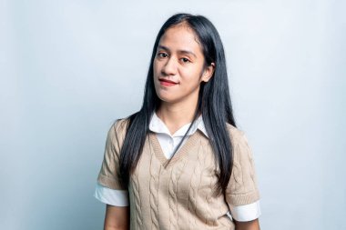 Güzel bir Güneydoğu Asyalı kadının yakın plan portresi şık ve tarafsız bir arkaplanda rahatça poz veriyor..