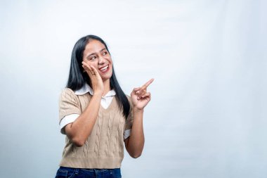 Mutlu, genç Endonezyalı bir kadın şaşırmış ve boş alanı işaret ediyor. Keşfi temsil ediyor, şaşırtıcı teklifler, ya da harika haberler..