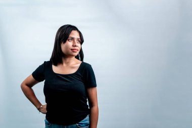 Gülümseyen Endonezyalı bir kadının portresi, eli kalçasında ve yana bakıyor, beyaz arka planda, kopyalama alanı ile izole edilmiş..