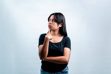 Siyah tişörtlü düşünceli bir Endonezyalı kadının portresi. Düşünen ve yan bakan, kopyalama alanı olan beyaz arka planda izole edilmiş..