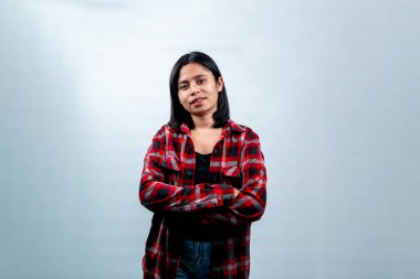 Kollarını kavuşturmuş gülümseyen Güneydoğu Asyalı bir kadının portresi. Beyaz arka plan, başarı konsepti ve Endonezya gençliği üzerine izole edilmiş stüdyo çekimi.