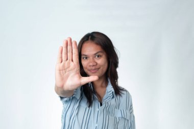 Mavi çizgili tişörtlü Endonezyalı kadın elini kameraya doğru 