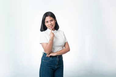 Beyaz tişörtlü Endonezyalı kadın yan tarafı işaret ediyor. Fotokopi alanı olan neşeli bir ifade. Beyazda izole edilmiş.