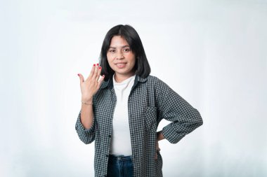 Ekose gömlekli, beyaz tişörtlü, kırmızı tırnaklarını gösteren Endonezyalı kadın. Gülümseyen dostça bir ifade. Beyazda izole edilmiş.