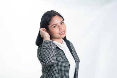 Saçına dokunan flanel gömlekli mutlu Endonezyalı bir kadının portresi. Öğrenci güveni, gençlik yaşam tarzı ve beyaz arka planda günlük akademik moda kavramı.