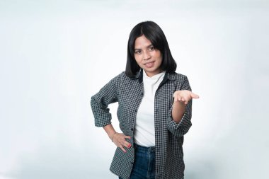 Gülümseyen Endonezyalı bir kadının portresi açık el hareketleriyle bir şey sunuyor. Temiz beyaz bir arkaplan üzerine günlük yaşam tarzı ve yardımcı hizmet kavramı.