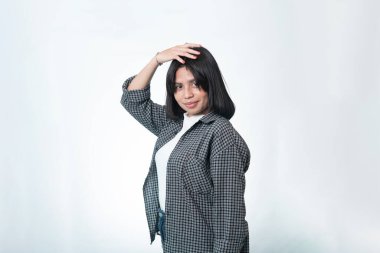 Ekose gömlek ve beyaz tişört giyen kendine güvenen Endonezyalı bir kadının portresi. Beyaz arka planda neşeli bir duruşu olan gündelik moda konsepti..