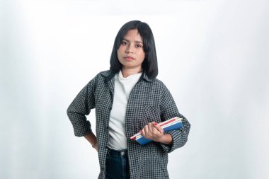 Stüdyoda renkli defterler tutan kendine güvenen Endonezyalı bir kadın. Beyaz arka planda temiz bir portre, eğitim ve kampüs hayatı kavramları için ideal.