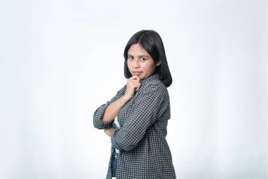 Ekose gömlekli düşünceli Endonezyalı bir kadının portresi. Karar verme, fikir üretme ve problem çözme kavramları için temiz stüdyo çekimi ideal..