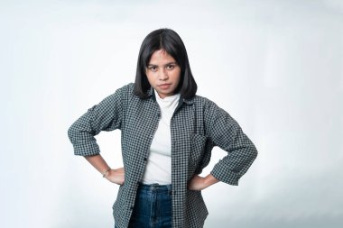 Elleri belinde poz veren sert bir Endonezyalı kadının portresi. Öfke, otorite ya da katı tutum kavramları için profesyonel stüdyo çekimi.