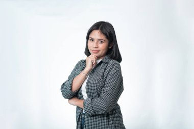 Ekose gömlekli düşünceli Endonezyalı bir kadının portresi. Karar verme, fikir üretme ve problem çözme kavramları için temiz stüdyo çekimi ideal..