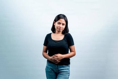 Beyaz bir arkaplan karşısında genç bir Endonezyalı kadının portresi, dostça bir ifadeyle kameraya bakıyor..