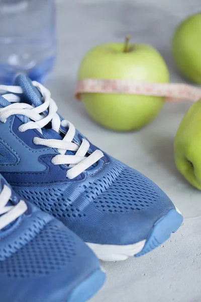 Zapatos deportivos, medidor, manzanas, botella de agua sobre fondo gris —  Fotos de Stock