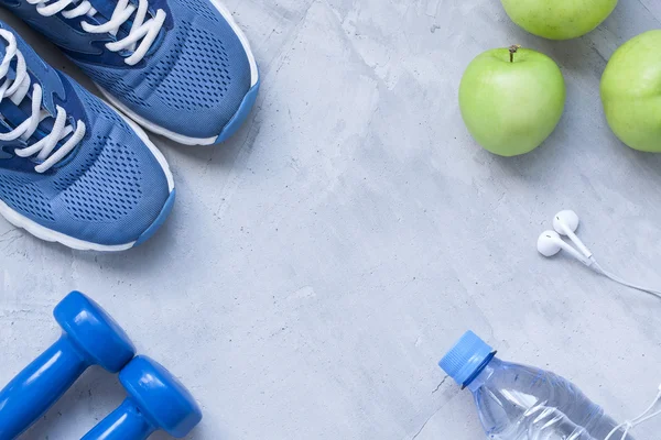 Plat lag sportschoenen met halters, koptelefoon, appels, fles water — Stockfoto