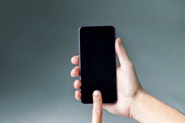 Tarafsız bir arkaplanda akıllı telefonu tutmak. Akıllı telefon konsepti. uygulama kavramı.