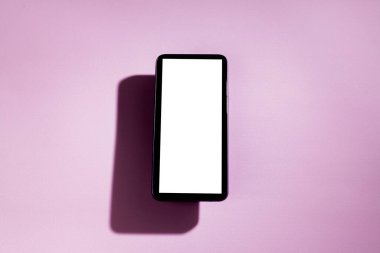 Pembe masanın üstünde beyaz ekranlı akıllı telefon. Cep telefonu konsepti. Beyaz ekran konsepti.