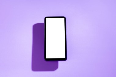 Mor masanın üstünde beyaz ekranlı akıllı telefon. Mor kavram. Beyaz ekran konsepti.