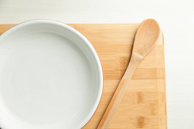 Masada tahta kesme tahtasıyla bir tabak yemek. Mesaj için yer var. Boşluğu kopyala.