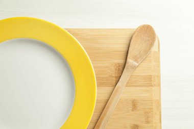 Masada tahta kesme tahtasıyla bir tabak yemek. Mesaj için yer var. Boşluğu kopyala.