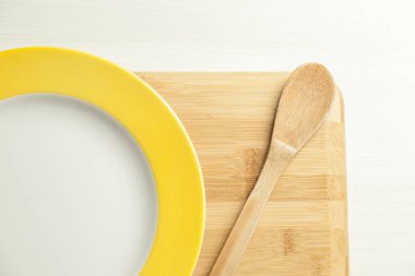 Masada tahta kesme tahtasıyla bir tabak yemek. Mesaj için yer var. Boşluğu kopyala.