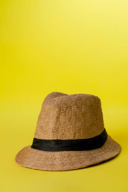 Sarı arka planda hasır şapka ve yaz teması. Mesaj için yer var. Şapka konsepti. Sombrero kavramı.
