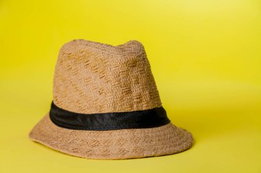 Sarı arka planda hasır şapka ve yaz teması. Mesaj için yer var. Şapka konsepti. Sombrero kavramı.