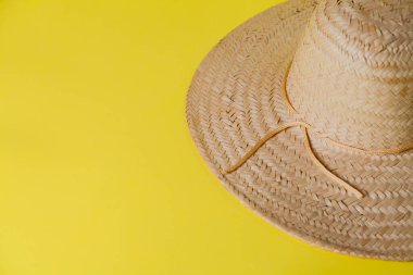 Sarı arka planda hasır şapka ve yaz teması. Mesaj için yer var. Şapka konsepti. Sombrero kavramı.