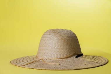 Sarı arka planda hasır şapka ve yaz teması. Mesaj için yer var. Şapka konsepti. Sombrero kavramı.