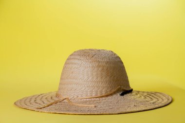Sarı arka planda hasır şapka ve yaz teması. Mesaj için yer var. Şapka konsepti. Sombrero kavramı.