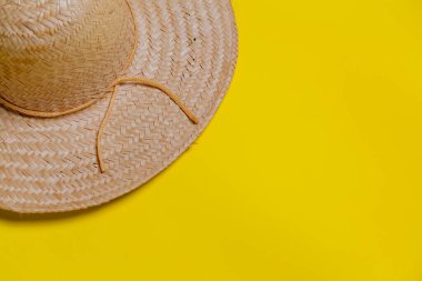 Sarı arka planda hasır şapka ve yaz teması. Mesaj için yer var. Şapka konsepti. Sombrero kavramı.