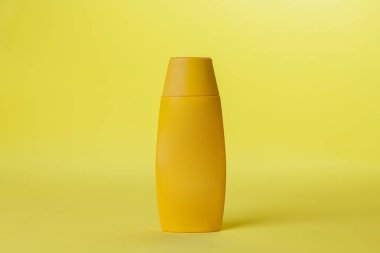 Renkli arka planda sarı güneş kremi şişesi. Güneş kremi. Deri bakımı konsepti. Mesaj için yer var. Model.