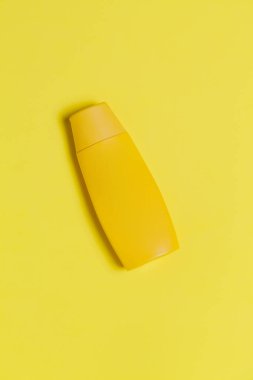 Renkli arka planda sarı güneş kremi şişesi. Güneş kremi. Deri bakımı konsepti. Mesaj için yer var. Model.