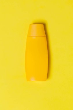 Renkli arka planda sarı güneş kremi şişesi. Güneş kremi. Deri bakımı konsepti. Mesaj için yer var. Model.