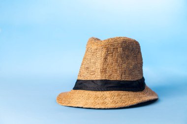 Mavi arka planda hasır şapka. Stüdyo fotoğrafı. Bohem konsepti. Şapka konsepti.