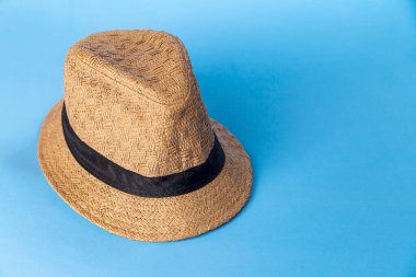 Mavi arka planda hasır şapka. Stüdyo fotoğrafı. Bohem konsepti. Şapka konsepti.