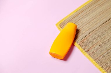 Pembe arka planda plaj paspası ve güneş kremi. Plaj konsepti. Kadınsı bir kavram. Metin için boşluk.