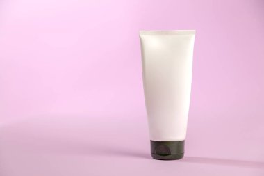 Pembe arka planda beyaz güneş kremi şişesi. Ürün konsepti. Güneş kremi. Boşluğu kopyala.