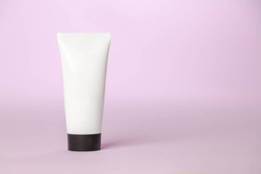 Pembe arka planda beyaz güneş kremi şişesi. Ürün konsepti. Güneş kremi. Boşluğu kopyala.