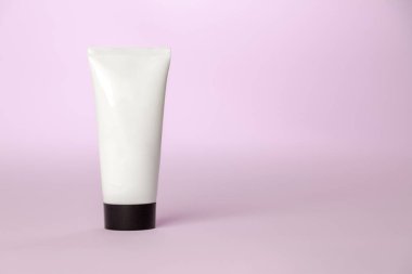 Pembe arka planda beyaz güneş kremi şişesi. Ürün konsepti. Güneş kremi. Boşluğu kopyala.