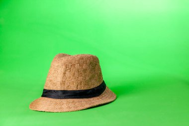 Yeşil arka planda hasır şapka. Hasır şapka konsepti. Klasik konsept. Metin için boşluk.