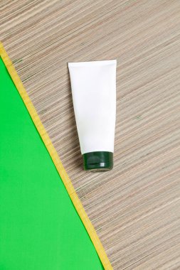 Yeşil arka planda yüz kremi kavanozu olan hasır paspas. Yaz kavramı. Yüz kremi konsepti. Metin için boşluk.