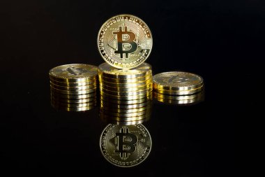 Altın bitcoinler kazanan podyum olarak istiflendi. Yansıması olan siyah bir arkaplanda izole edilmiş