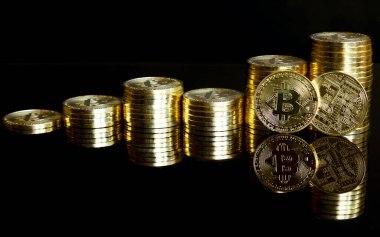 Grafik olarak istiflenmiş altın bitcoin 'ler. Siyah bir arkaplanda yansıması olan.