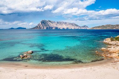 Beyaz kumlu bir plajı, gür çam ormanları ve engebeli dağları olan bir turkuaz körfez manzarası, Sardunya, İtalya