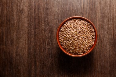 Pişmemiş mercimek yukarıdan koyu renkli ahşap izole Rustik Seramik kase