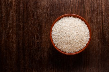 Yukarıdan koyu renkli ahşap izole çiğ çiğ beyaz pirinç Rustik Seramik kase